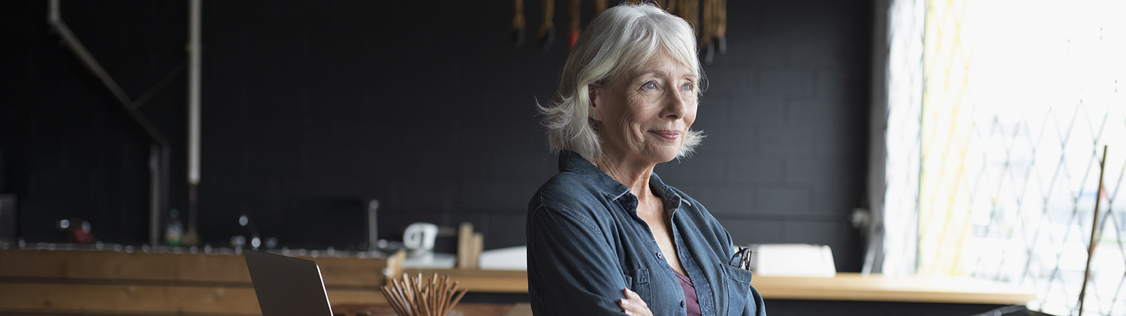 une dame dans une pièce regardant par la fenêtre