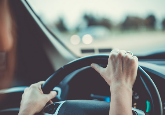 visuel d'un volant et les mains posées dessus