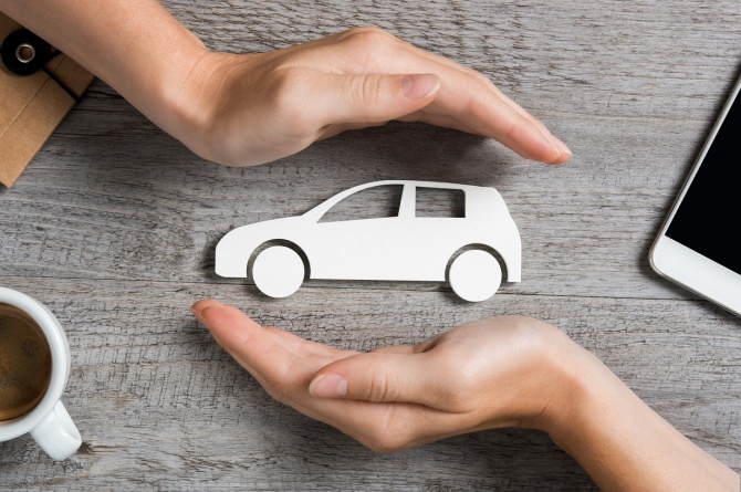 une voiture en papier en 2 mains