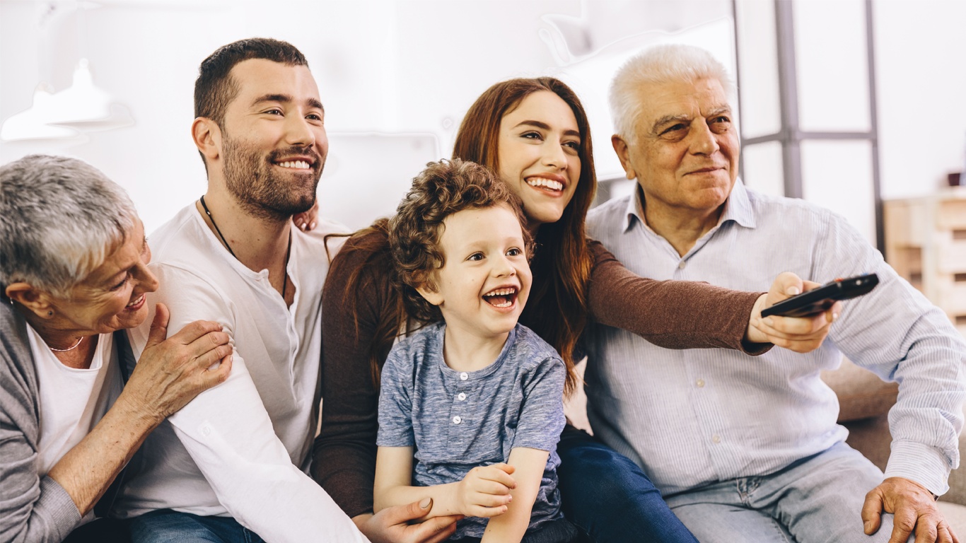 Famille souriante au complet dans un salon