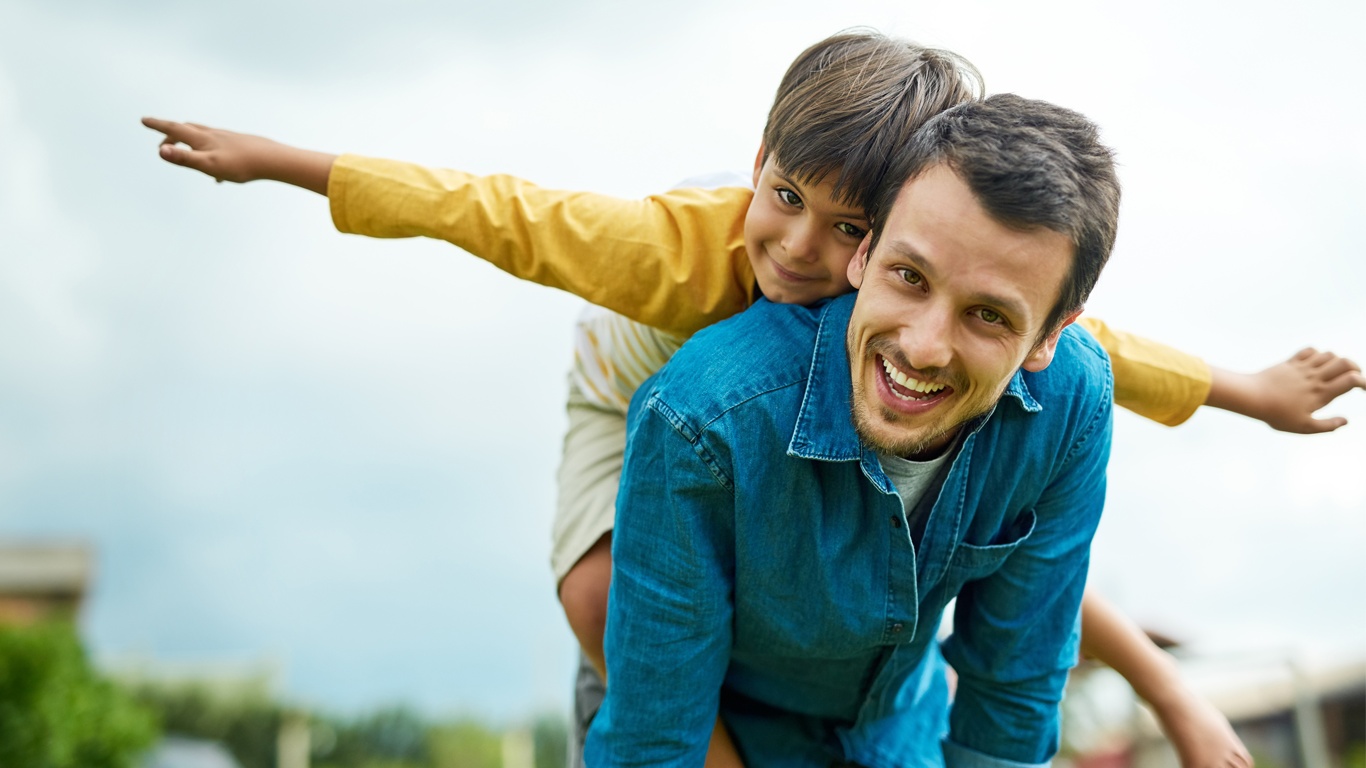 Un père et son fils souriants dans un champ